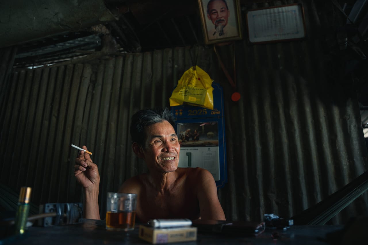 An older Rotenese man with betel-stained teeth outside a village home on Rote