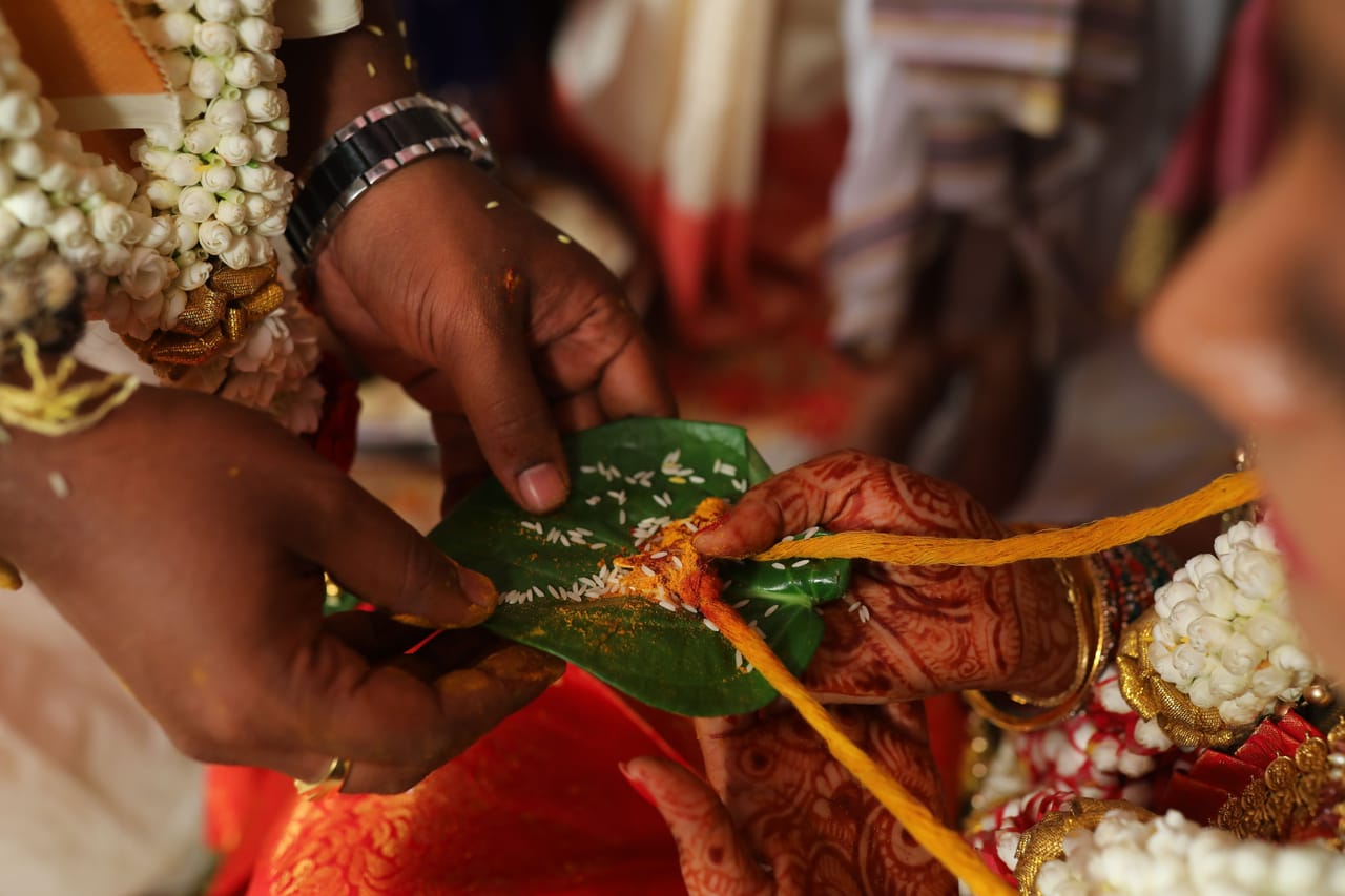 A guest accepting a betel bundle with both hands from an elder inside a Rotenese home