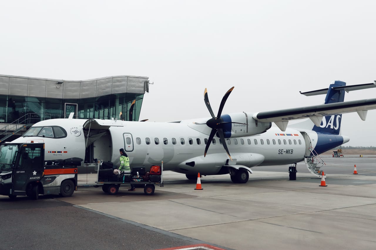 Handlers loading surfboard bags and cargo into the hold of an ATR 72 turboprop