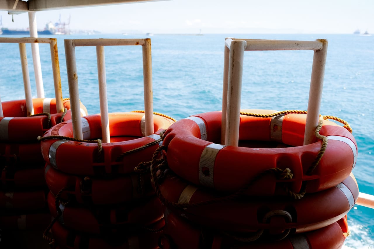 Board bags strapped on the deck of a fast ferry crossing turquoise water to Rote