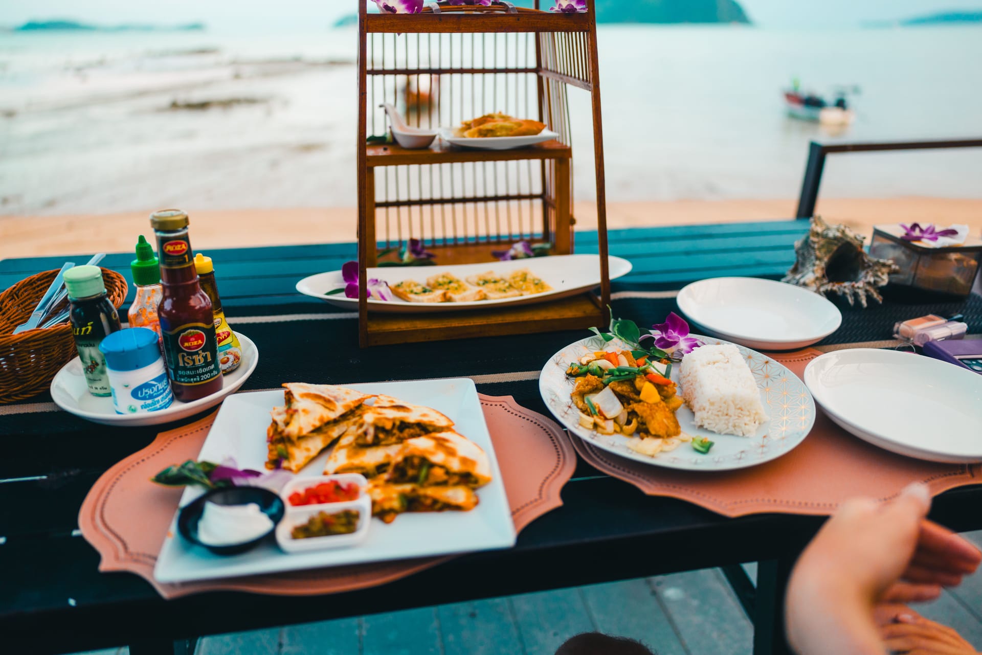 A beachfront warung on Rote at dawn with local food and scooters parked on a dirt road