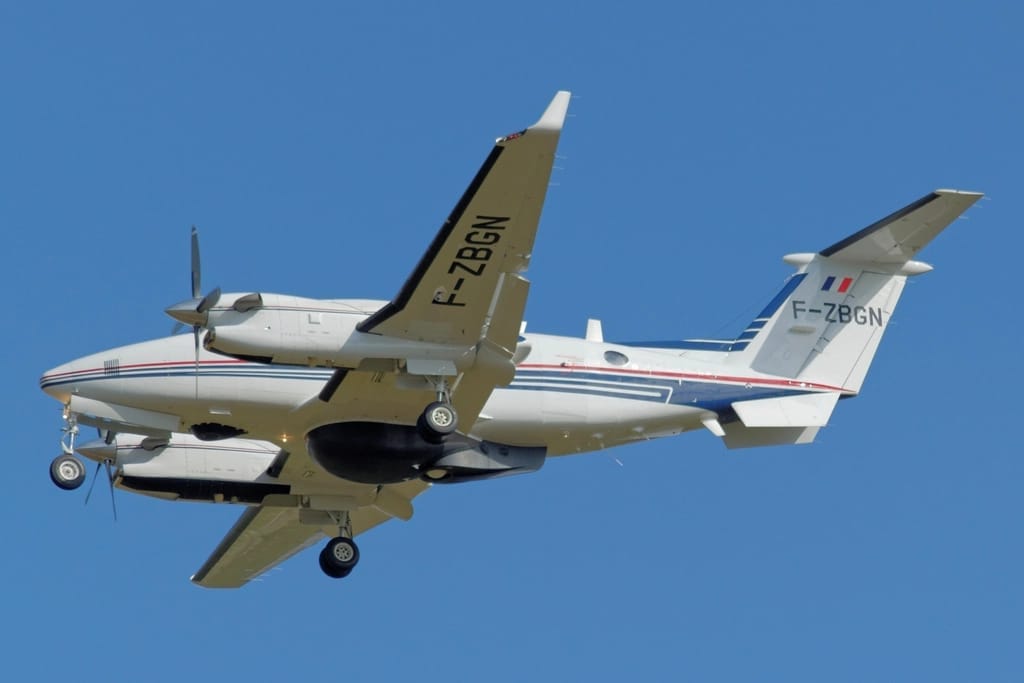 A propeller plane parked on the tarmac of a small regional airport in eastern Indonesia at golden hour