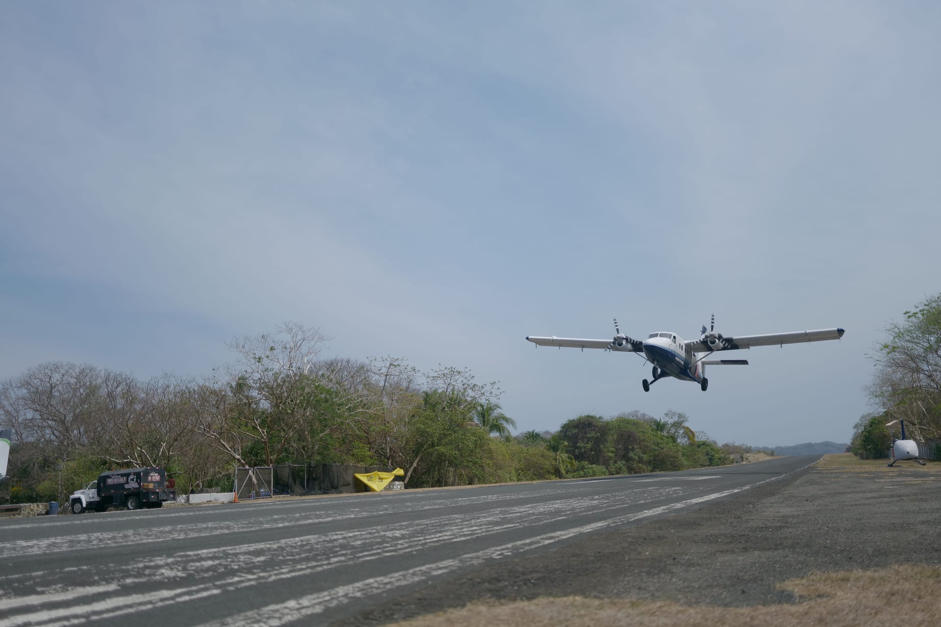 Small propeller plane at a tropical airport with travelers boarding for the short crossing to Rote