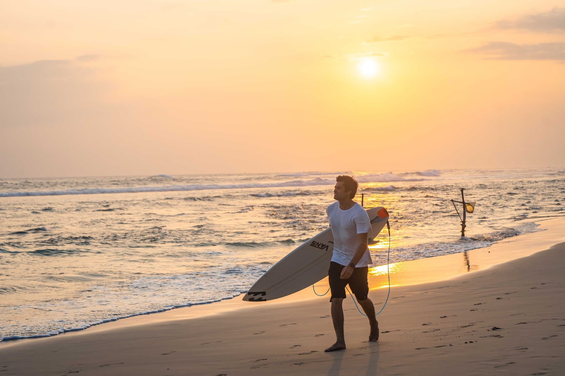 Remote worker using a laptop at a beachfront warung on Rote island at dawn