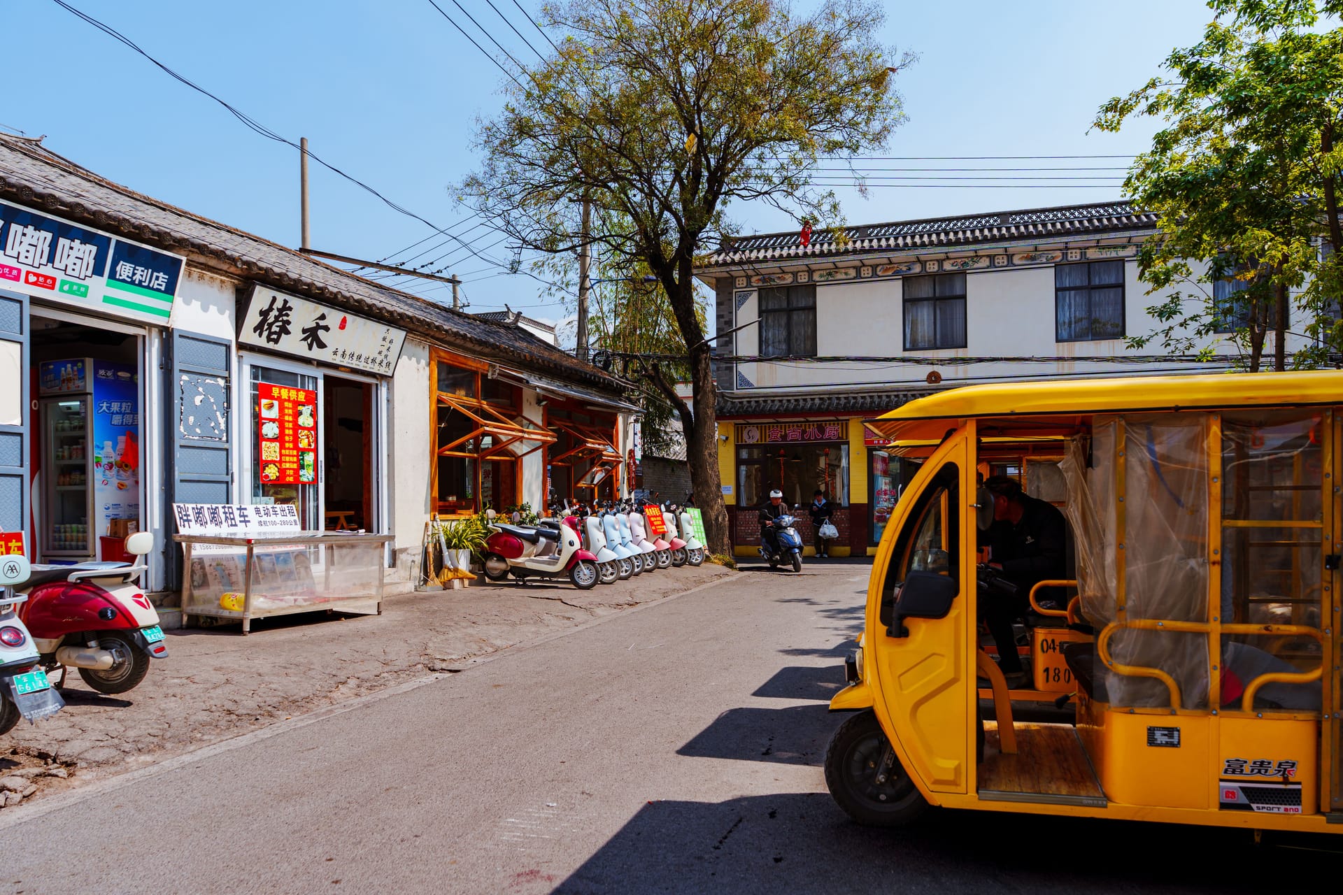 A quiet village street on Rote island at dawn with closed shops and an Indonesian flag on a public holiday