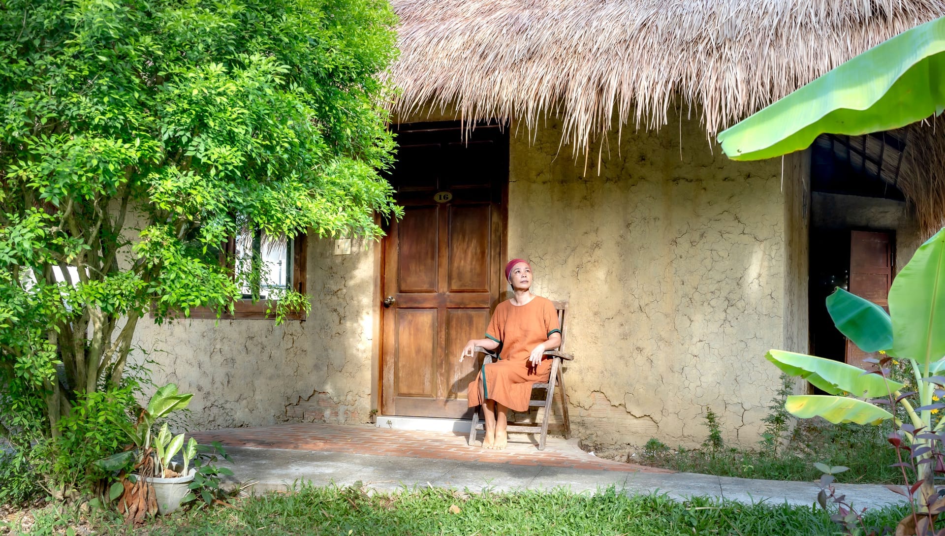 Retired foreigner on the porch of a simple beachfront home on Rote island in early morning light