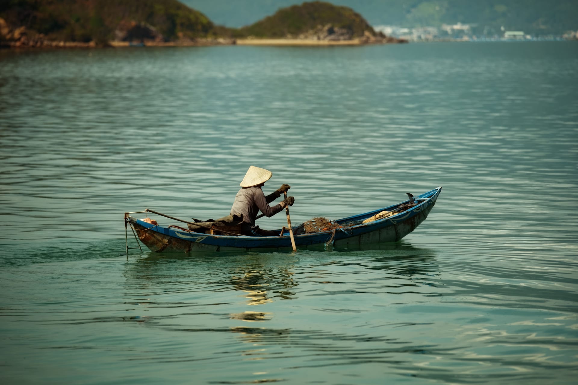 A wooden outrigger boat crossing the Savu Sea between islands near Rote at dawn