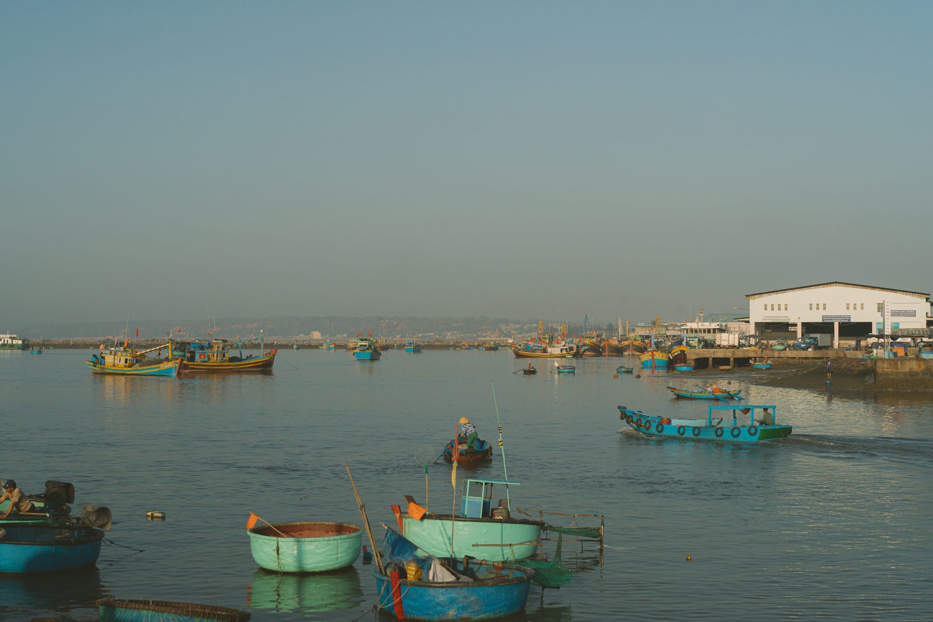Kupang harbour on Timor at dawn with ferries, fishing boats and locals along the waterfront