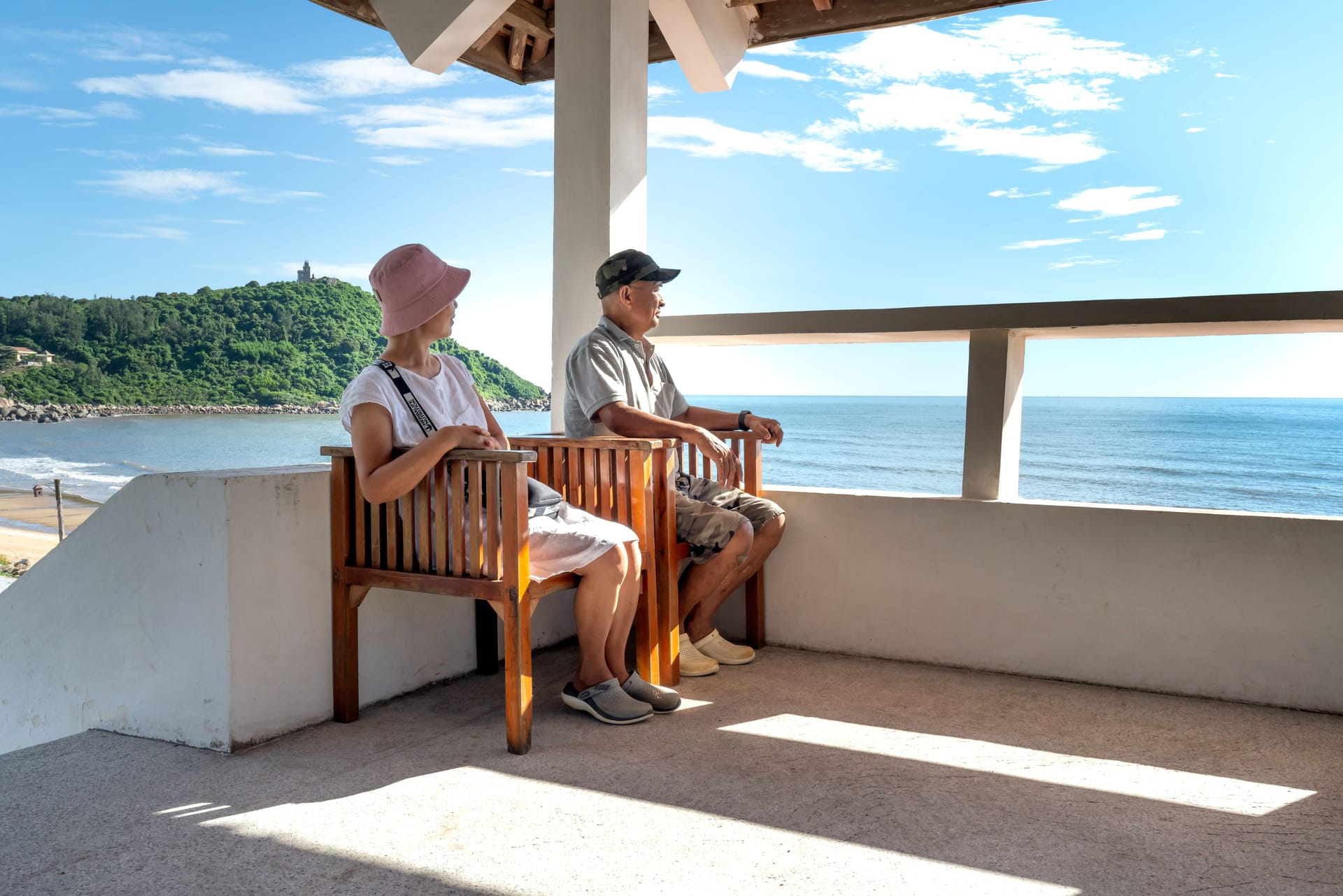 A foreign retiree sitting outside a beachfront warung on Rote at dawn, chatting with a local