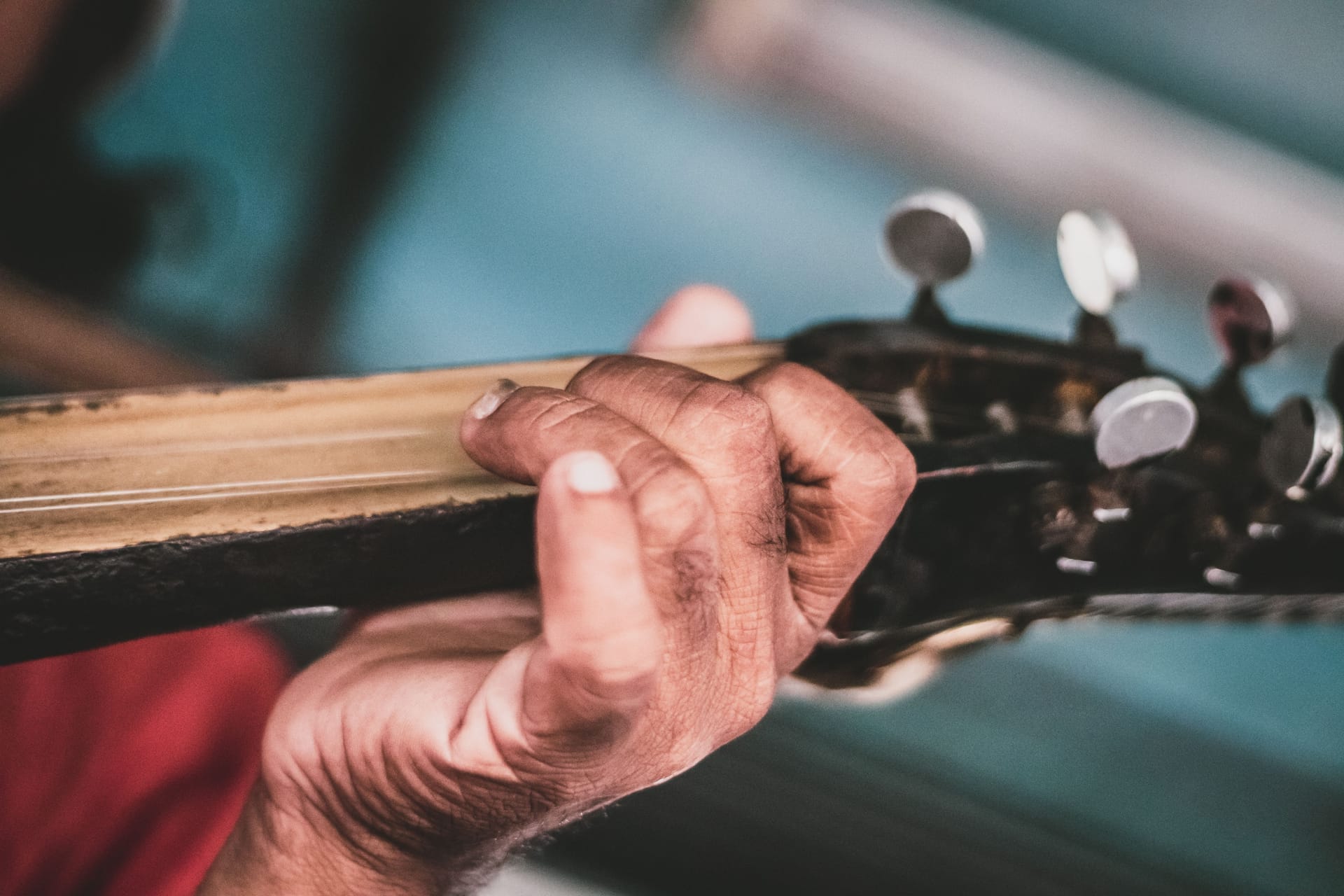 A Rotenese musician playing a sasando, hands reaching into the bamboo tube surrounded by a fan of dried lontar-palm leaves