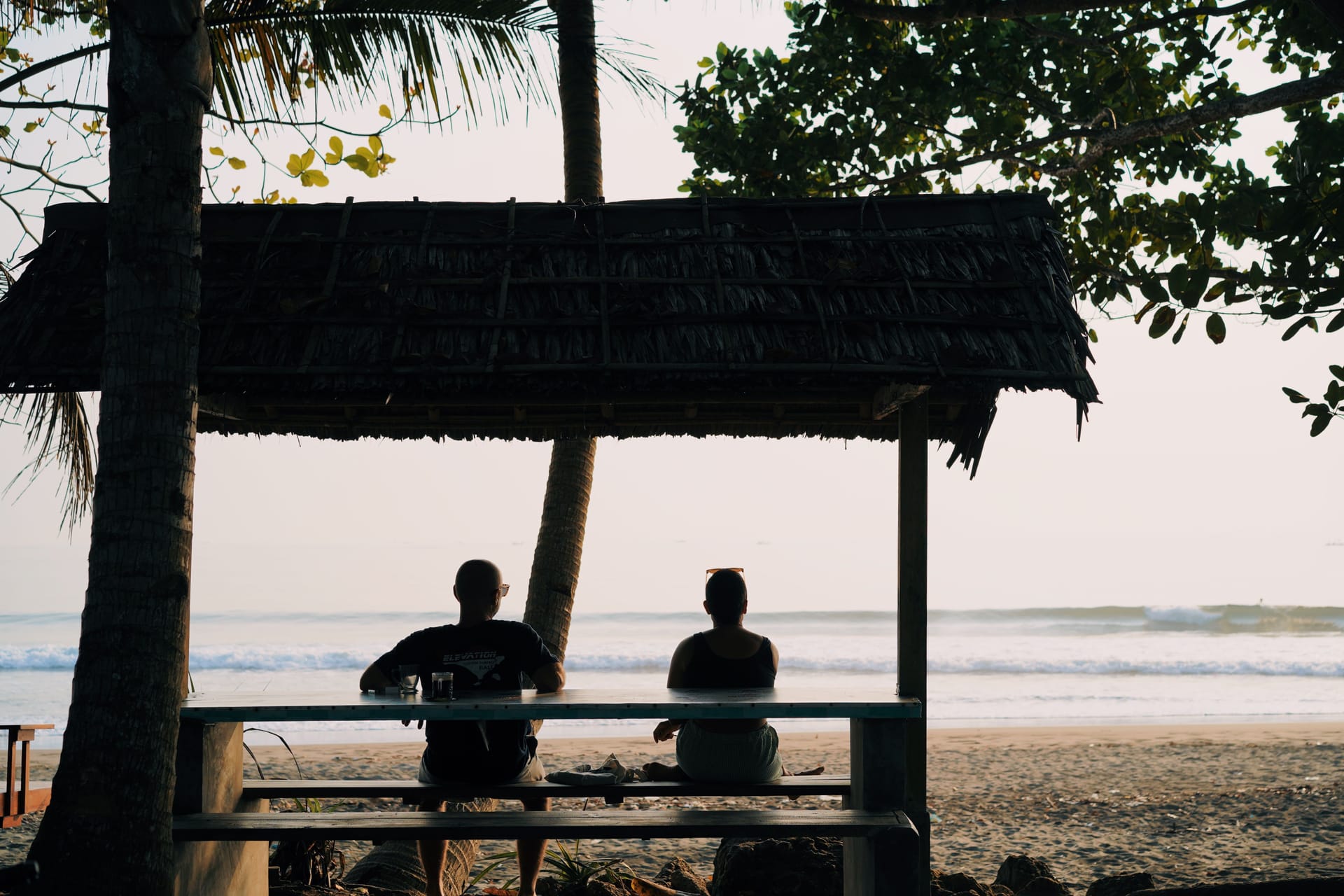 Remote worker on a Rote Island beachfront porch on a late-afternoon video call, laptop open, ocean behind
