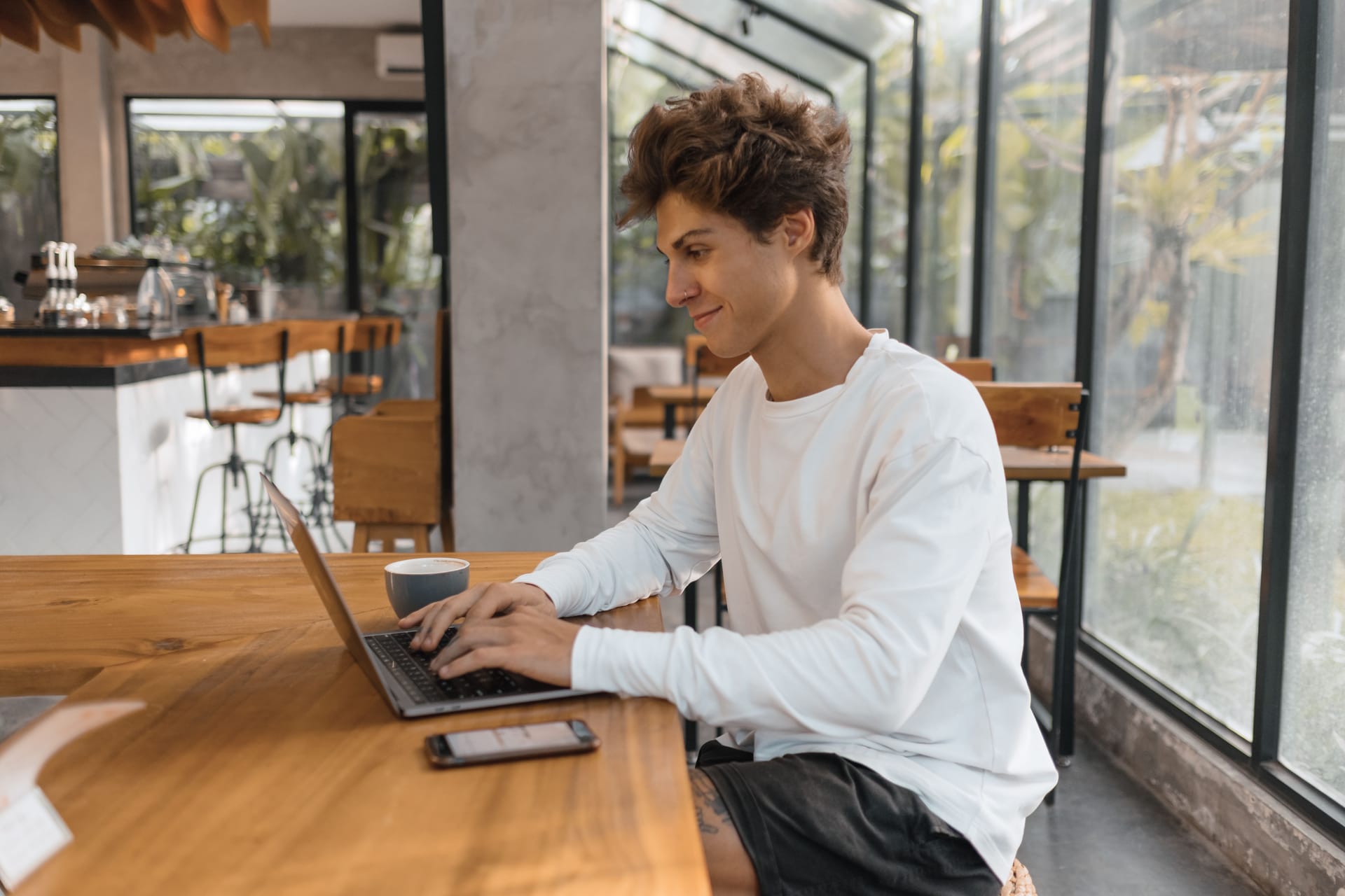 A foreign resident filing an online visa extension on a laptop in a Rote warung, passport beside them