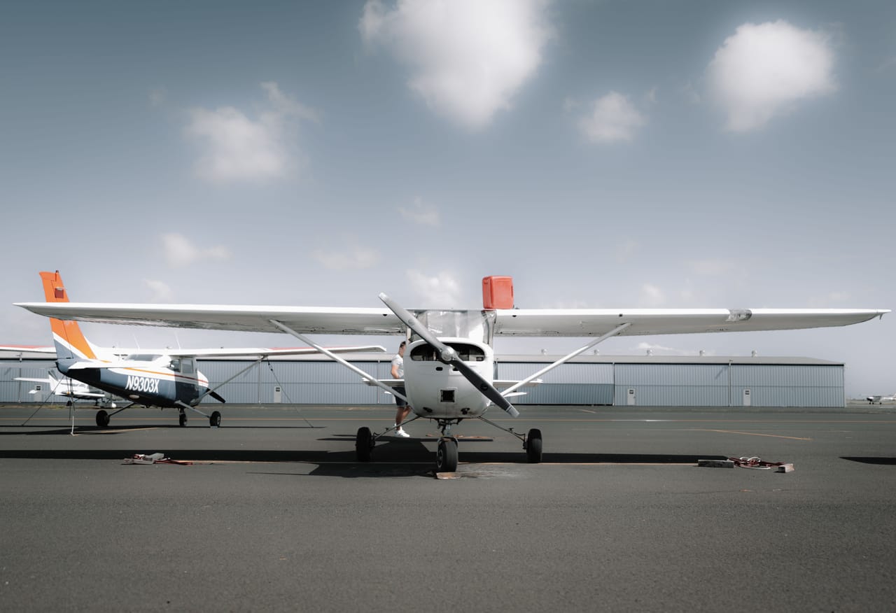 A small Susi Air propeller plane loading luggage at a remote island airstrip
