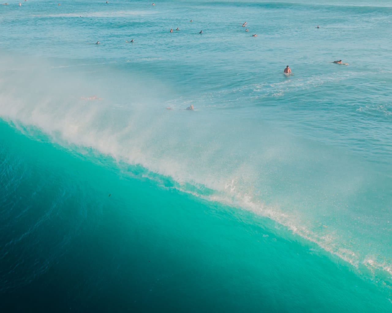 Clean groundswell lines wrapping toward a reef corner off Rote at golden hour with offshore spray