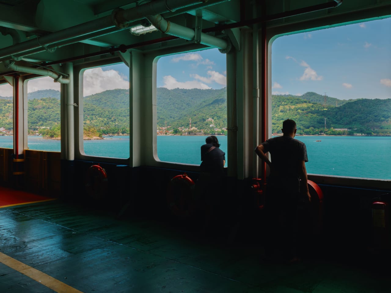 A local ferry crossing the strait between Timor and Rote in the late afternoon, with motorbikes and passengers aboard