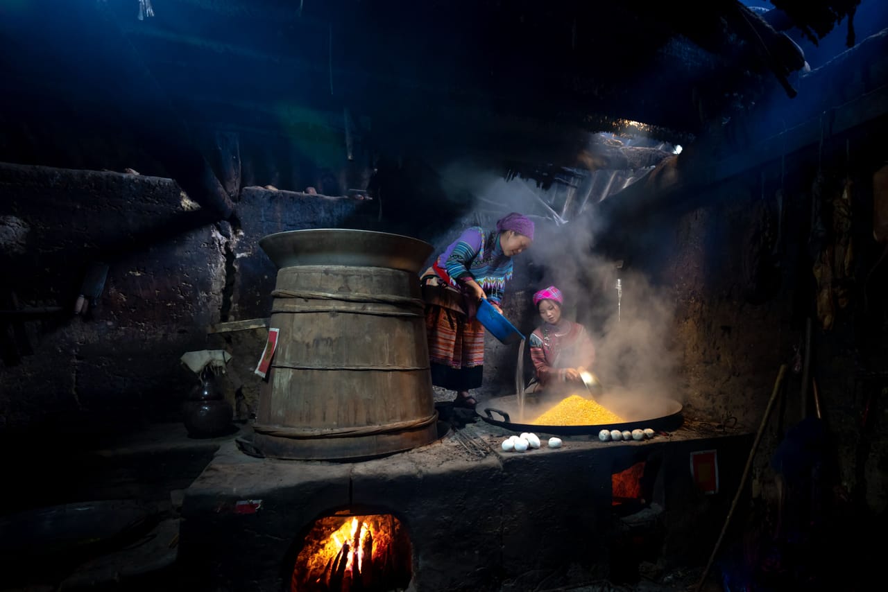 Village neighbours cooking and setting up chairs together for a community wedding on Rote