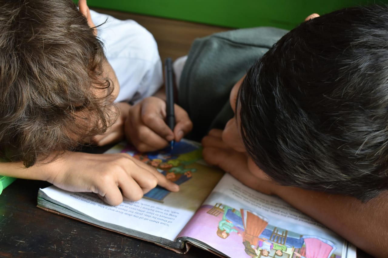 A child studying at a desk in a modest classroom in Kupang, Indonesia