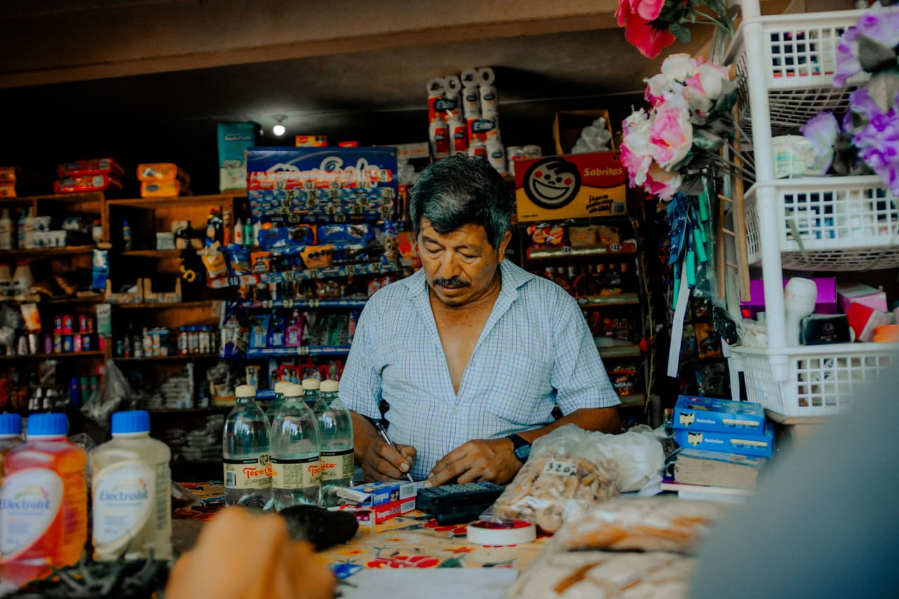 A small roadside warung and shop in Nemberala selling everyday goods with bottled fuel out front