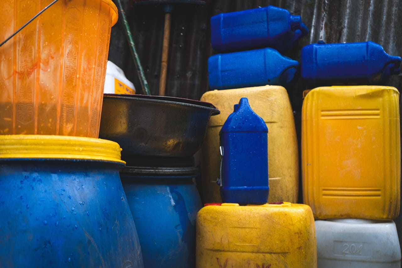 Empty water jerry cans stacked beside a roadside in an inland Rote village waiting for the water truck during the dry season