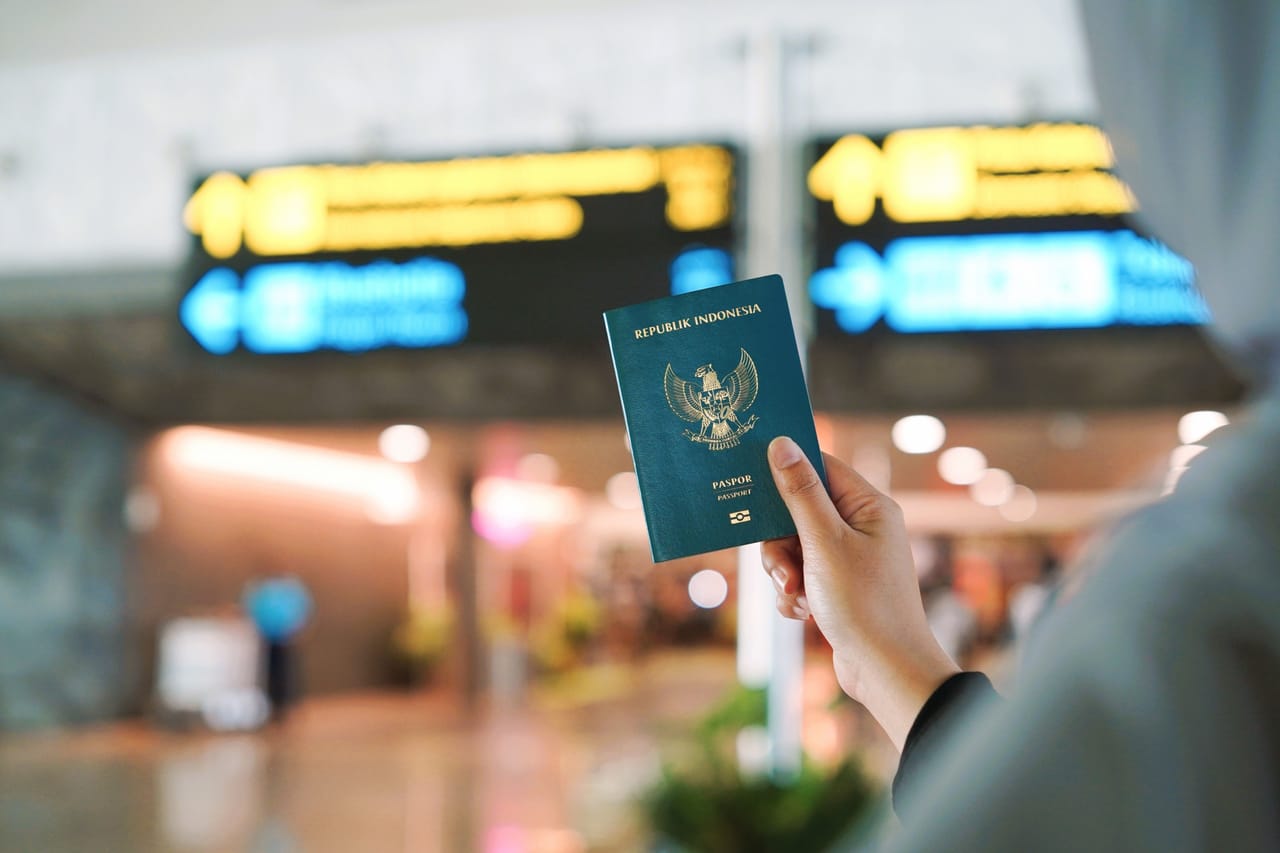 A passport, a driving licence and a folded permit booklet arranged on a wooden table
