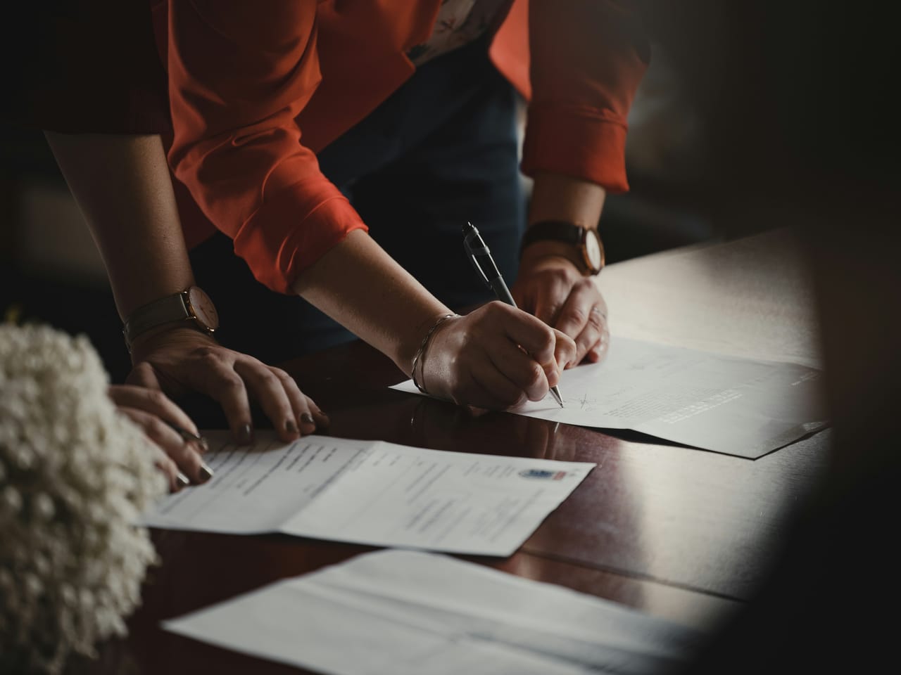 A person handing documents across a government office counter