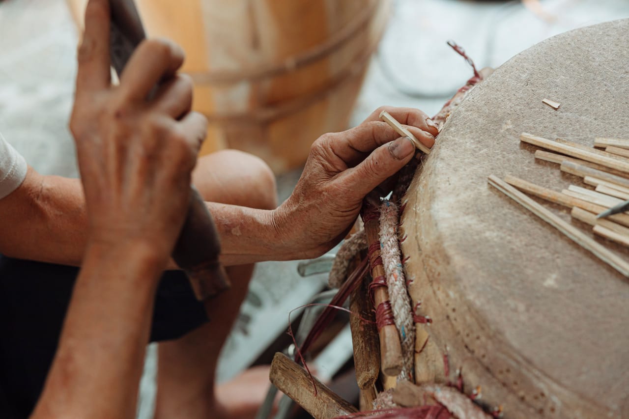 A person collecting sap from the top of a tall lontar palm