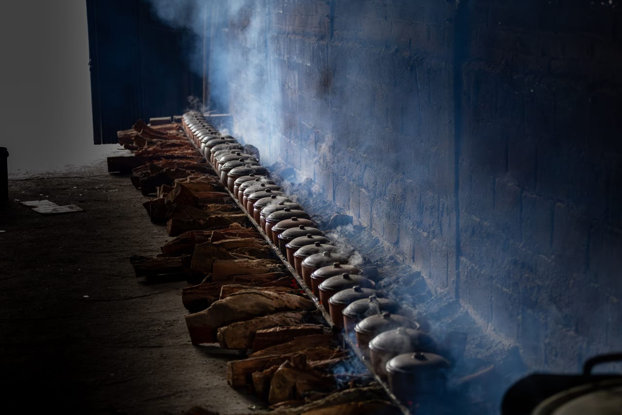 Villager boiling lontar palm sap into gula sabu sugar stored in clay Eru pots on Savu