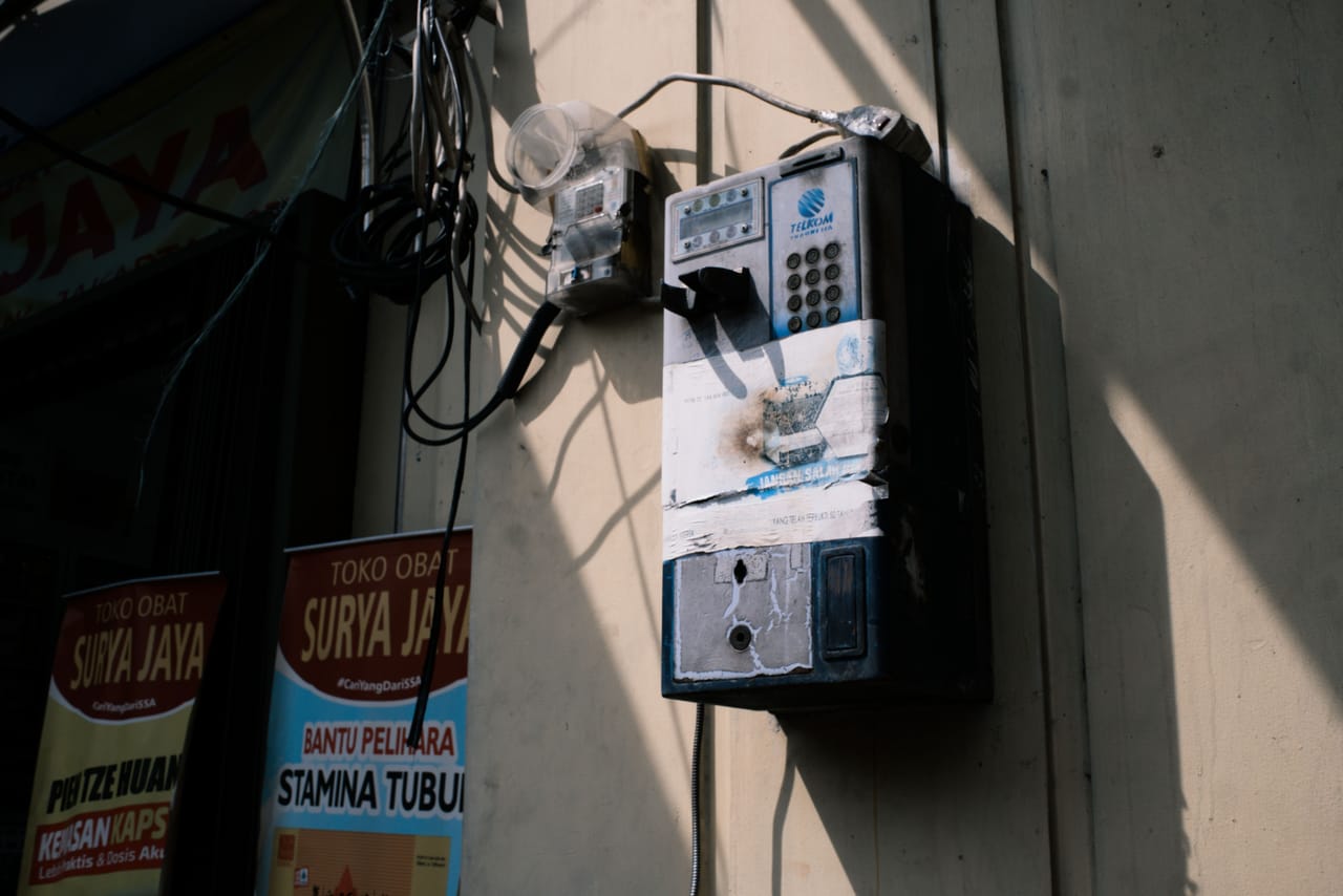 Telkomsel and XL prepaid SIM cards and top-up vouchers on a small shop counter in Ba'a, Rote
