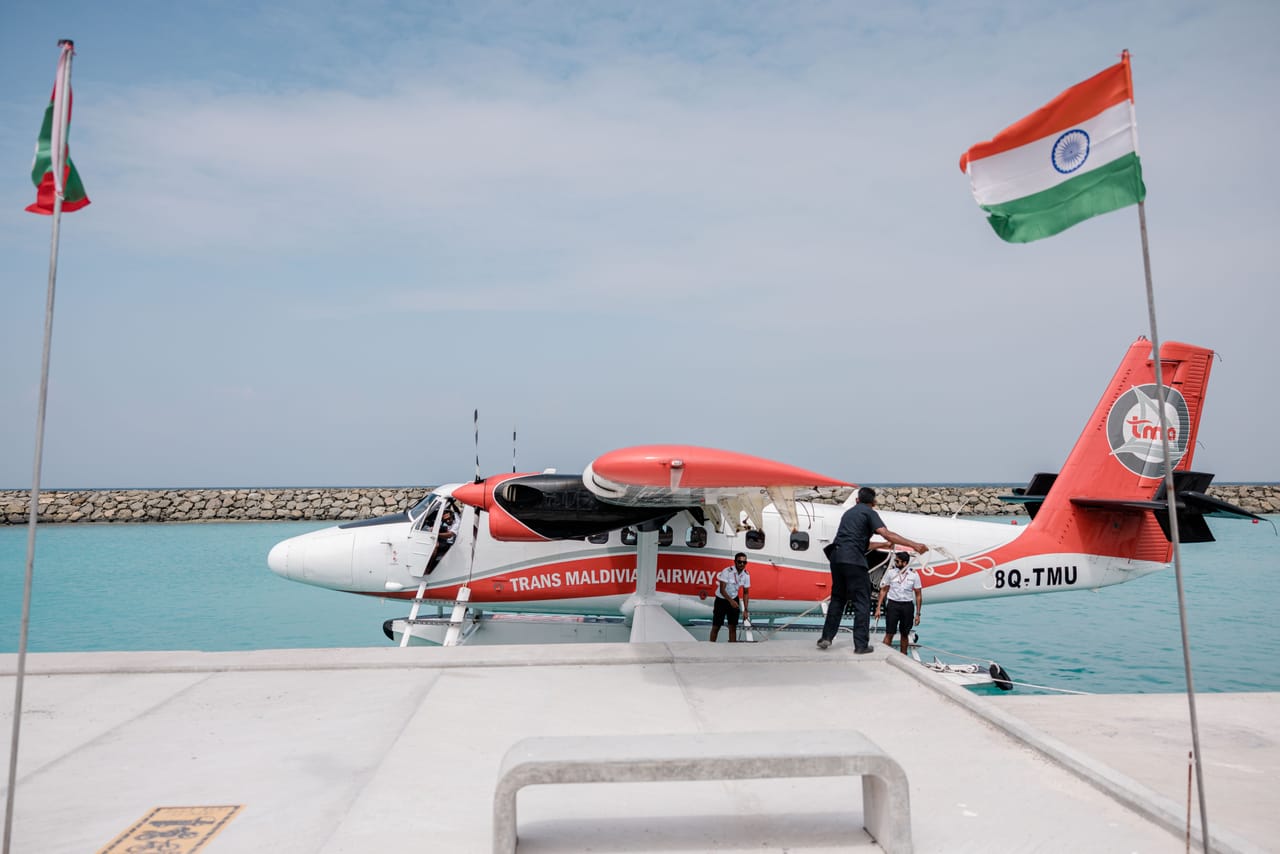 Surfboards in a padded coffin bag loaded onto a small propeller plane on a remote island airstrip