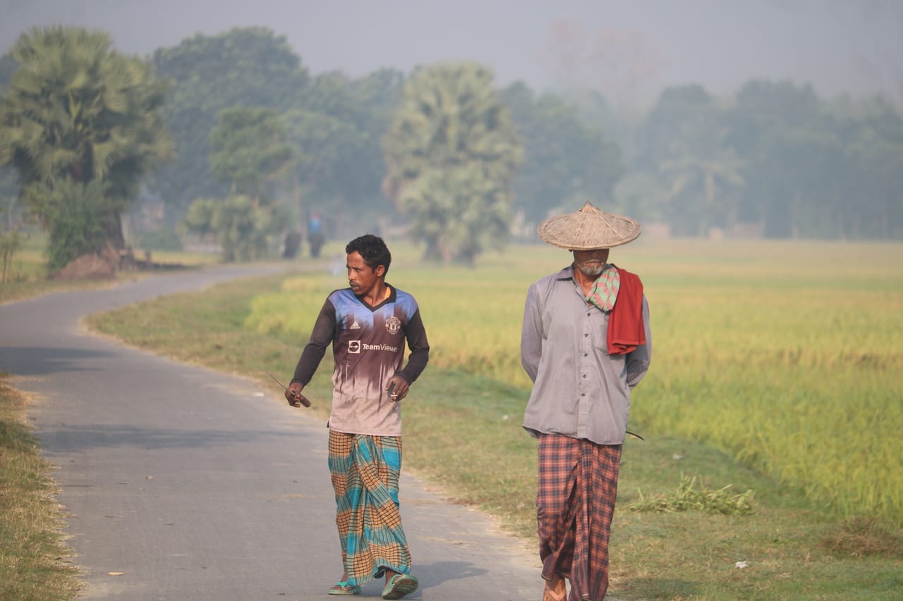Two Rotenese men talking on a dirt road between village plots on Rote